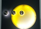 Grundtafel in Wunschfarbe mit auf Abstand montierten Edelstahl Edelstahl Halbkugeln. Das die gelbe Kugel ist eine Acrylglasscheibe mit einem transluzenten Digitaldruck. Kuglen mit LED`s hinterleuchtet ist. Komplett montagefertige Platte.